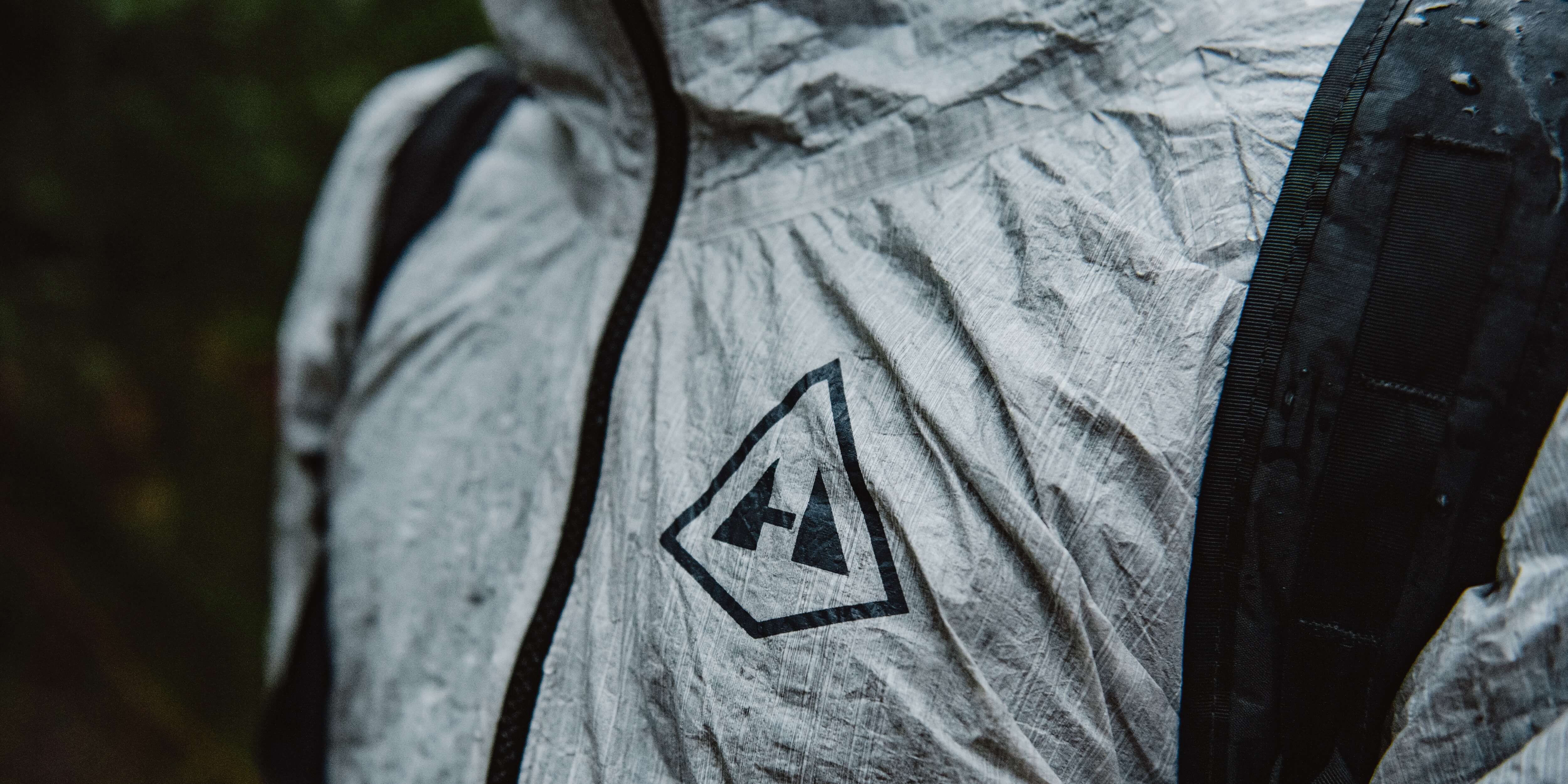 A man wearing a rain jacket with a backpack.