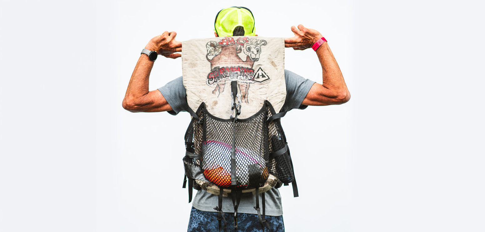 A hiker from behind showing off intricate, custom artwork drawn on their white Hyperlite Mountain Gear Windrider backpack.