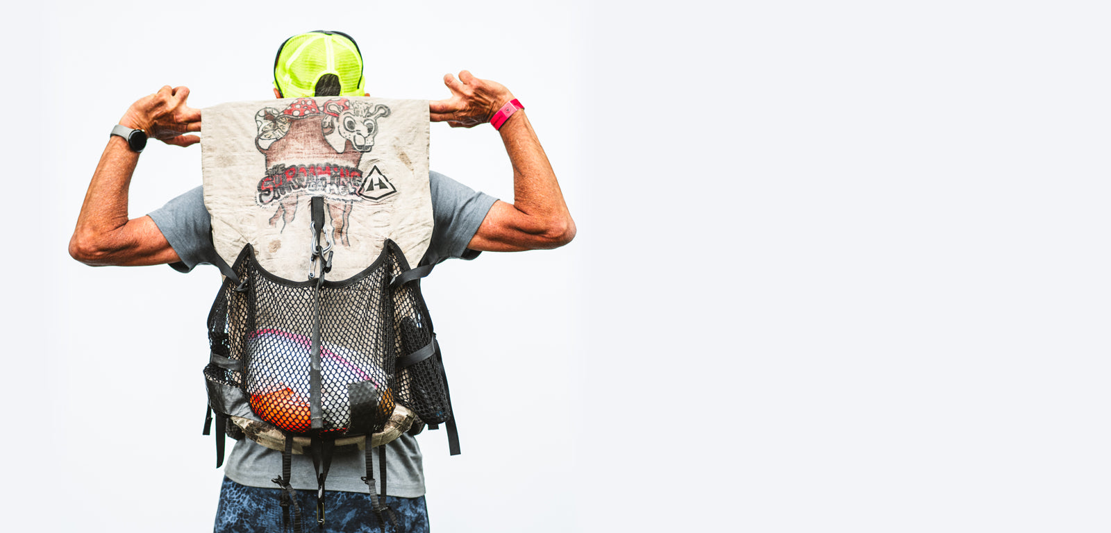 A hiker from behind showing off intricate, custom artwork drawn on their white Hyperlite Mountain Gear Windrider backpack.