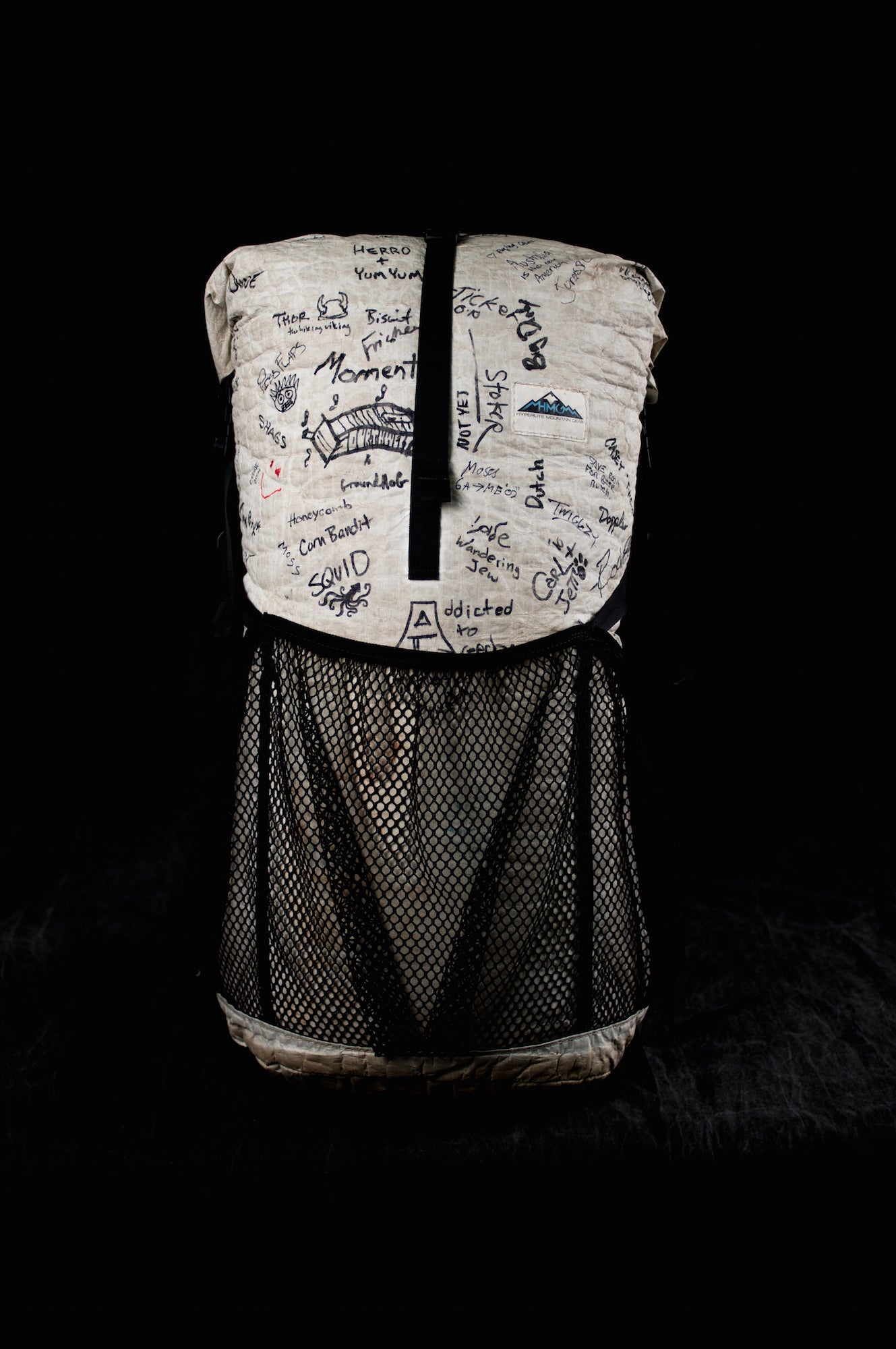 A backpack with a lot of writing on it.