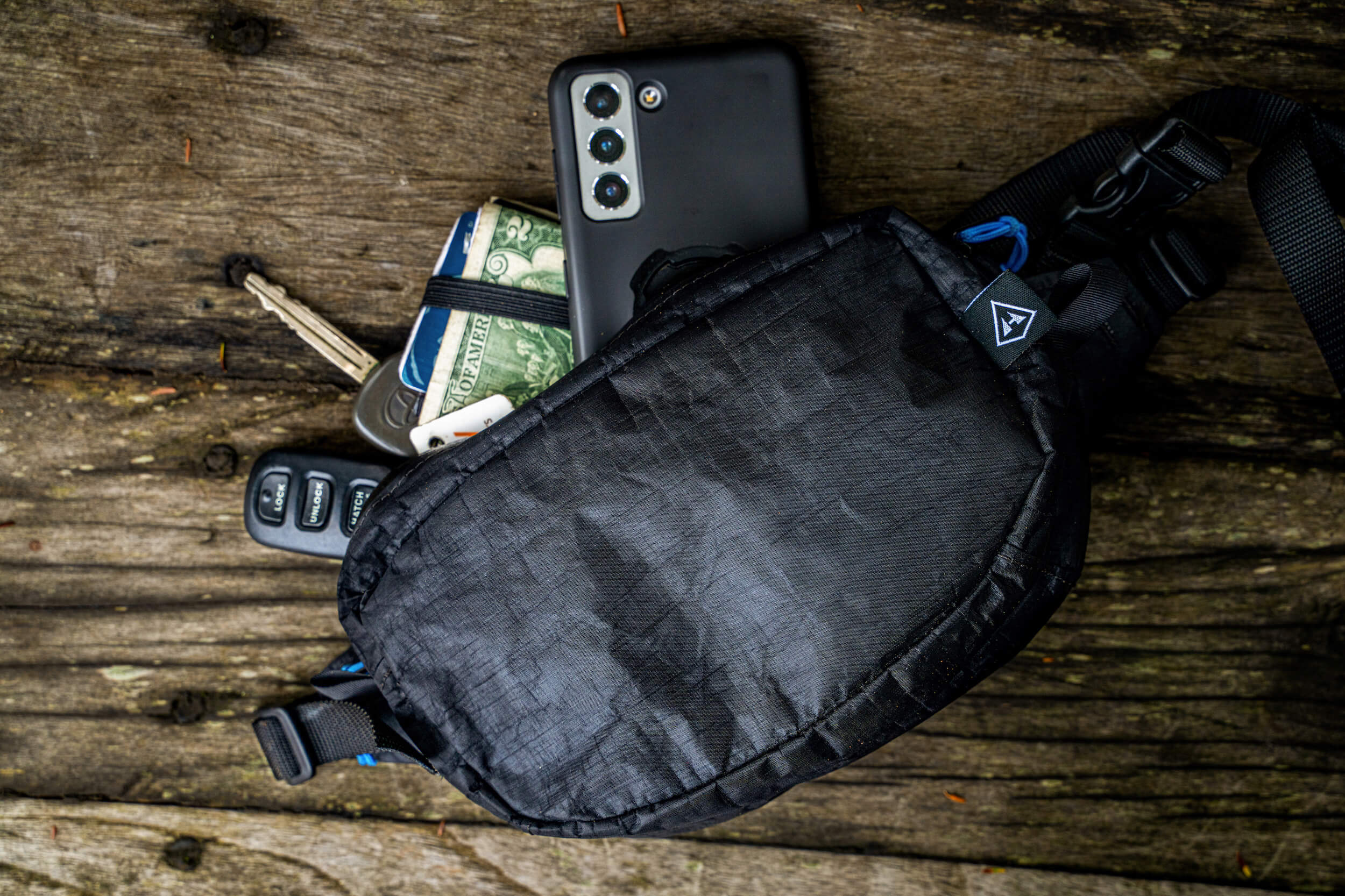 A fanny pack with a cell phone and other items.