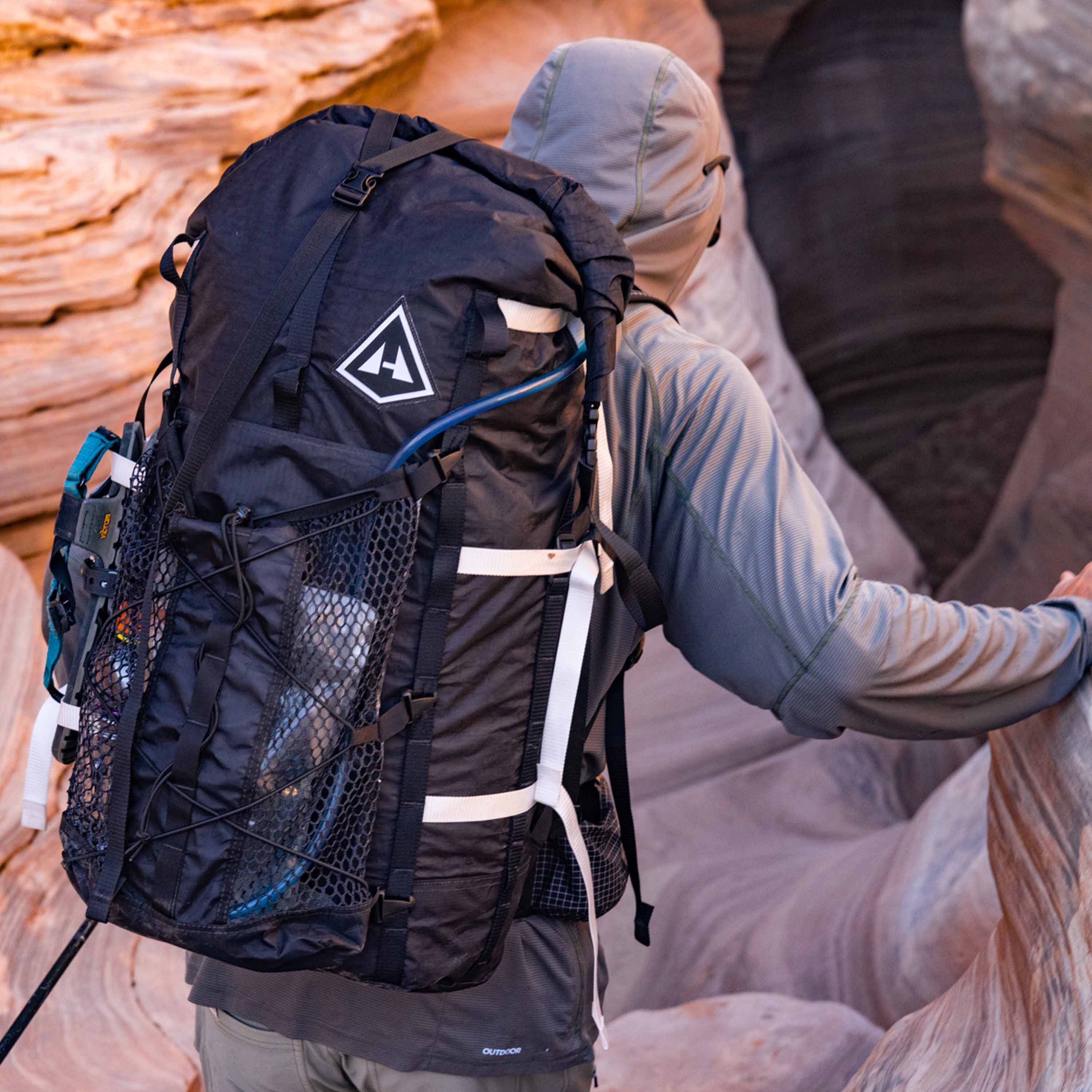 A hiker utilizing the Hyperlite Mountain Gear Porter Accessory Bundle with gear stashed in the stuff pocket