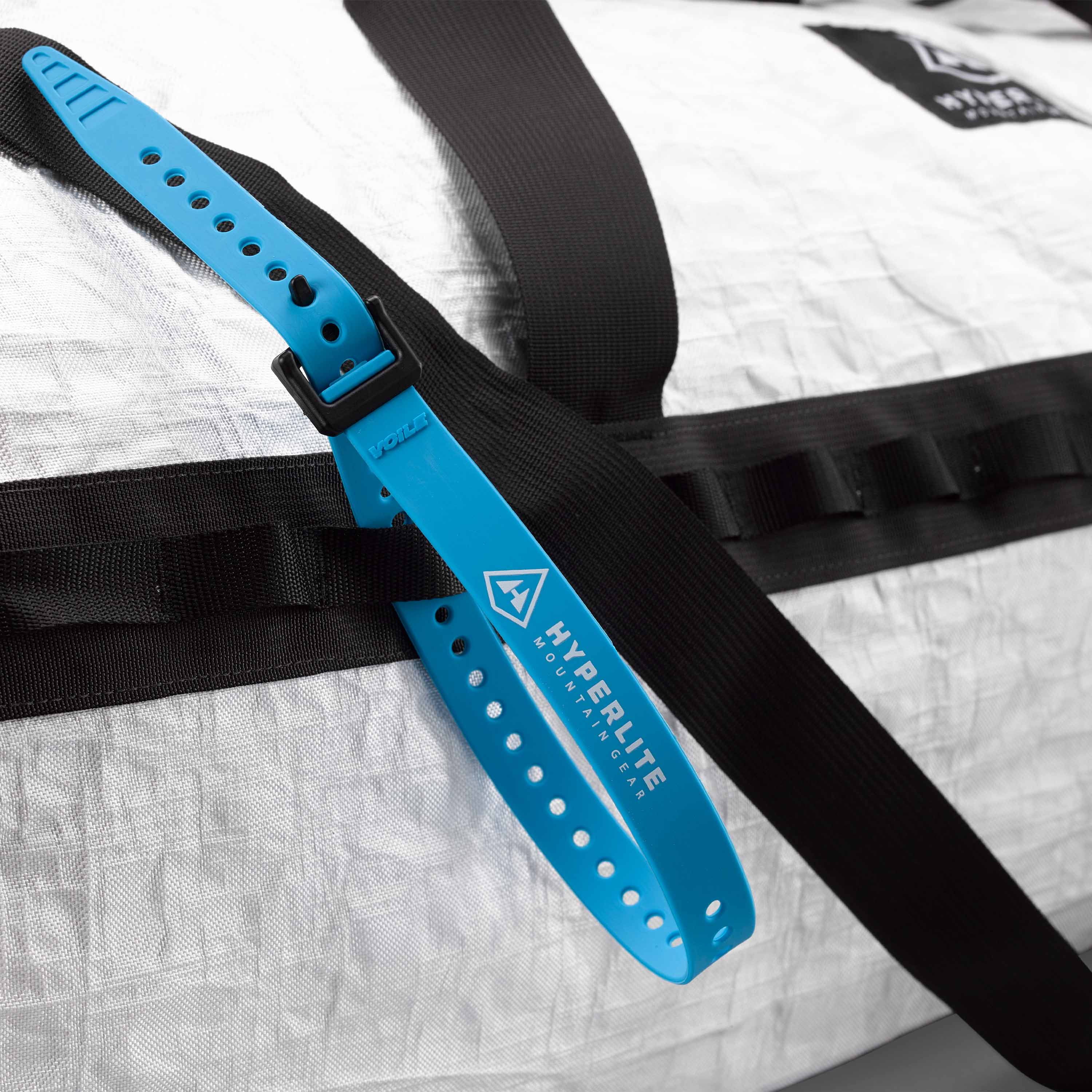 A close up view of a Voile Strap running through one of the 2 full-length daisy chains on the Hyperlite Mountain Gear 140L Approach Duffel