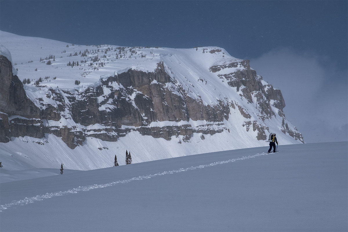 an adventurer traverses the snow at altitude