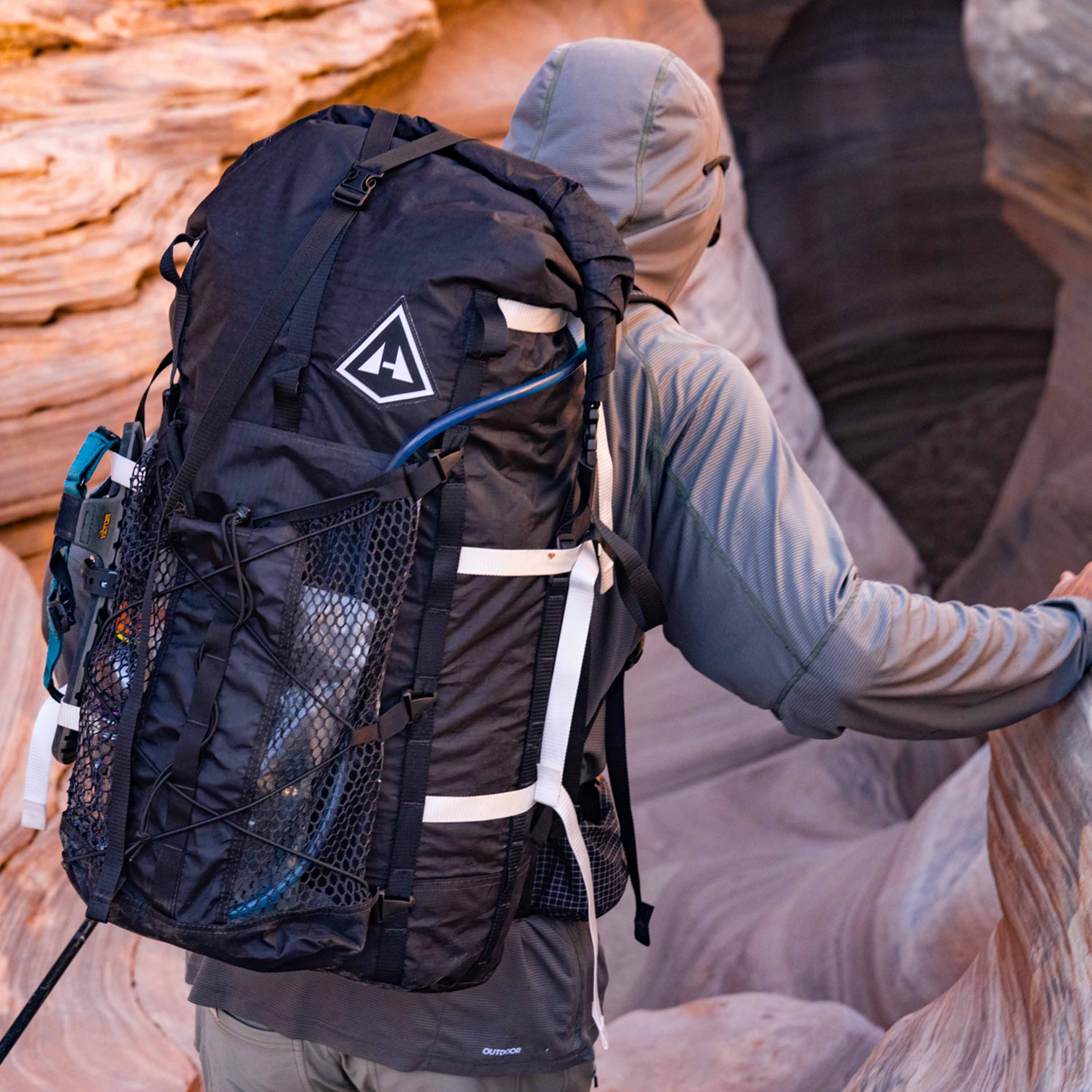Hiker wearing Hyperlite Mountain Gear's Porter Stuff Pocket attached to their pack in the canyon
