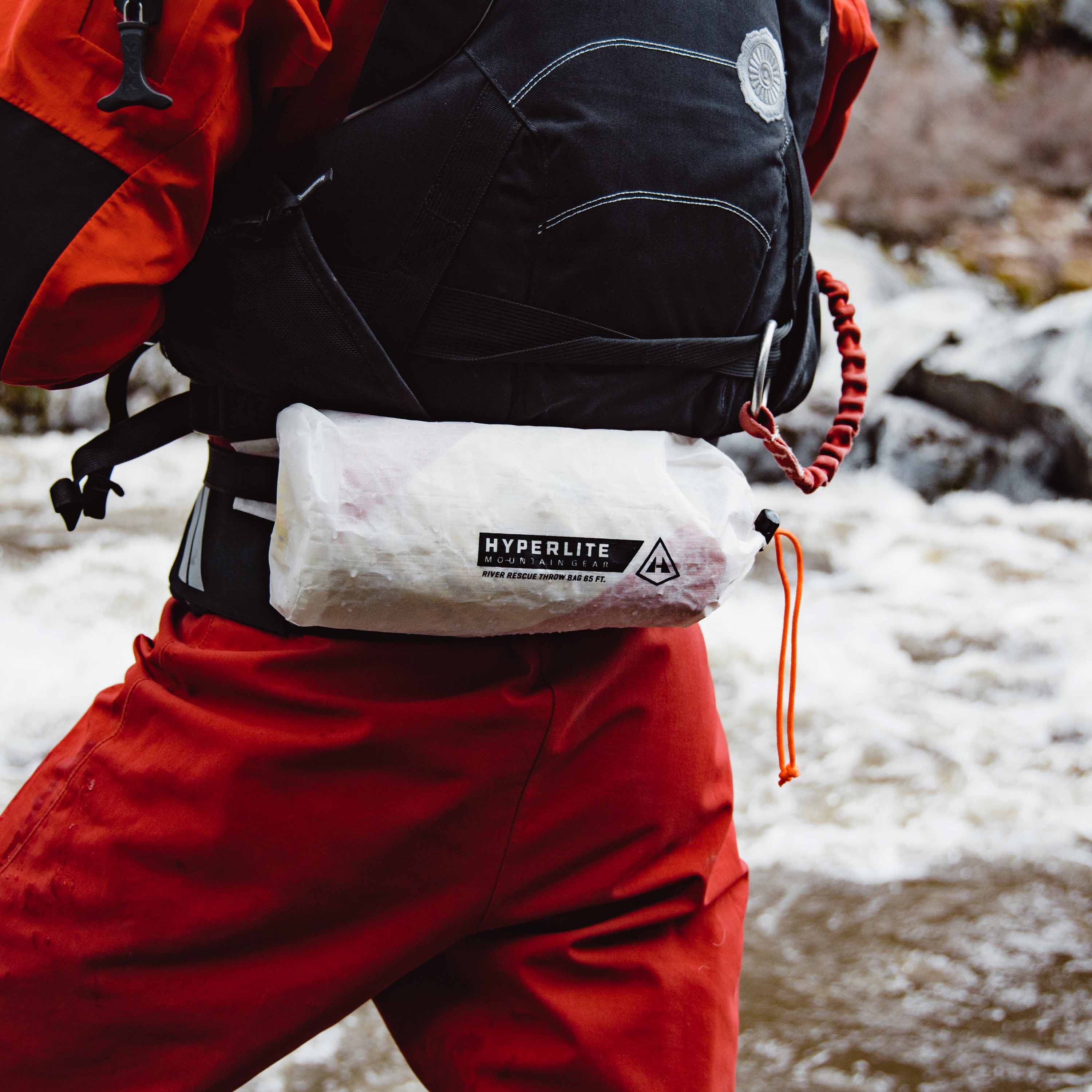 A rescuer stores the Hyperlite Mountain Gear River Rescue Throw Bag in the External waist pack with removable inner throw bag