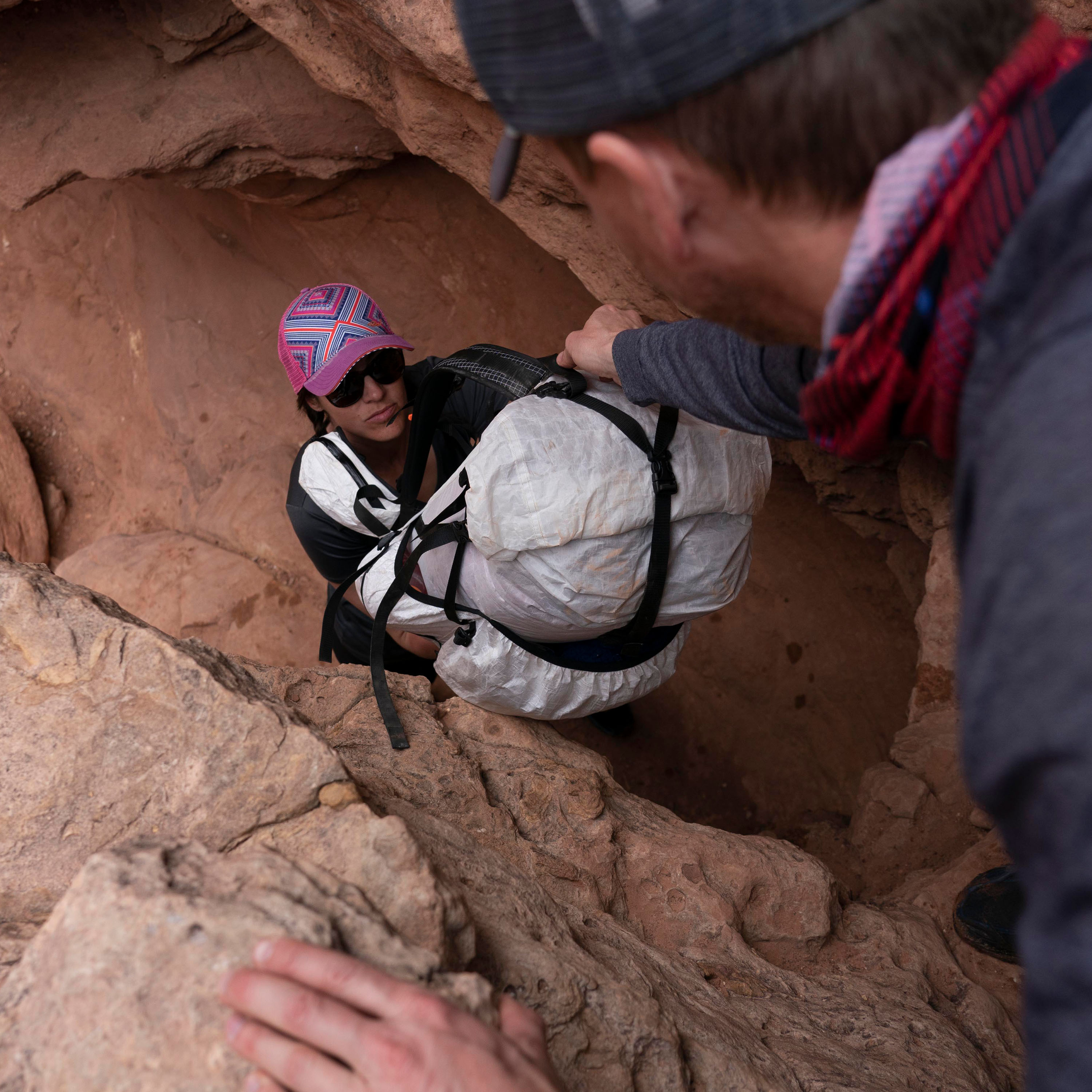 Hiker passing Hyperlite Mountain Gear's NorthRim 70 Pack in White to colleague in the canyon