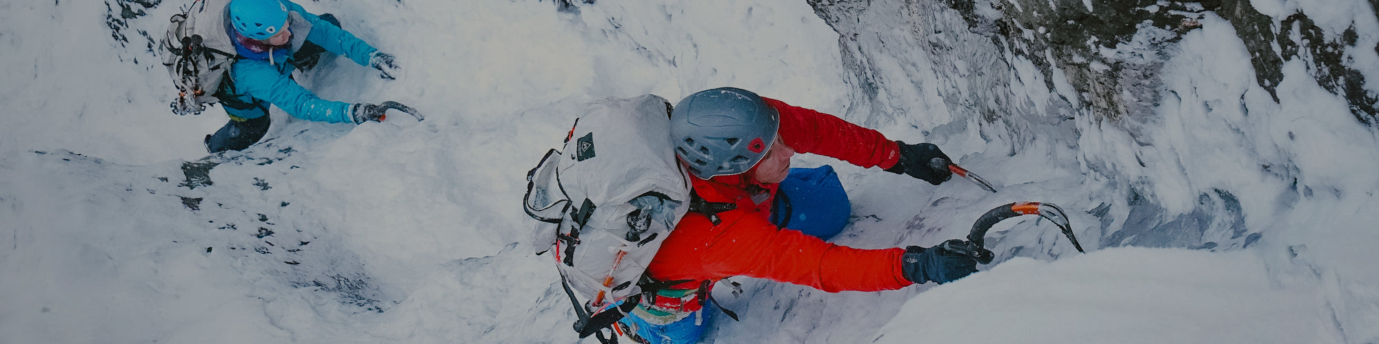 Two people skiing down a snowy mountain.