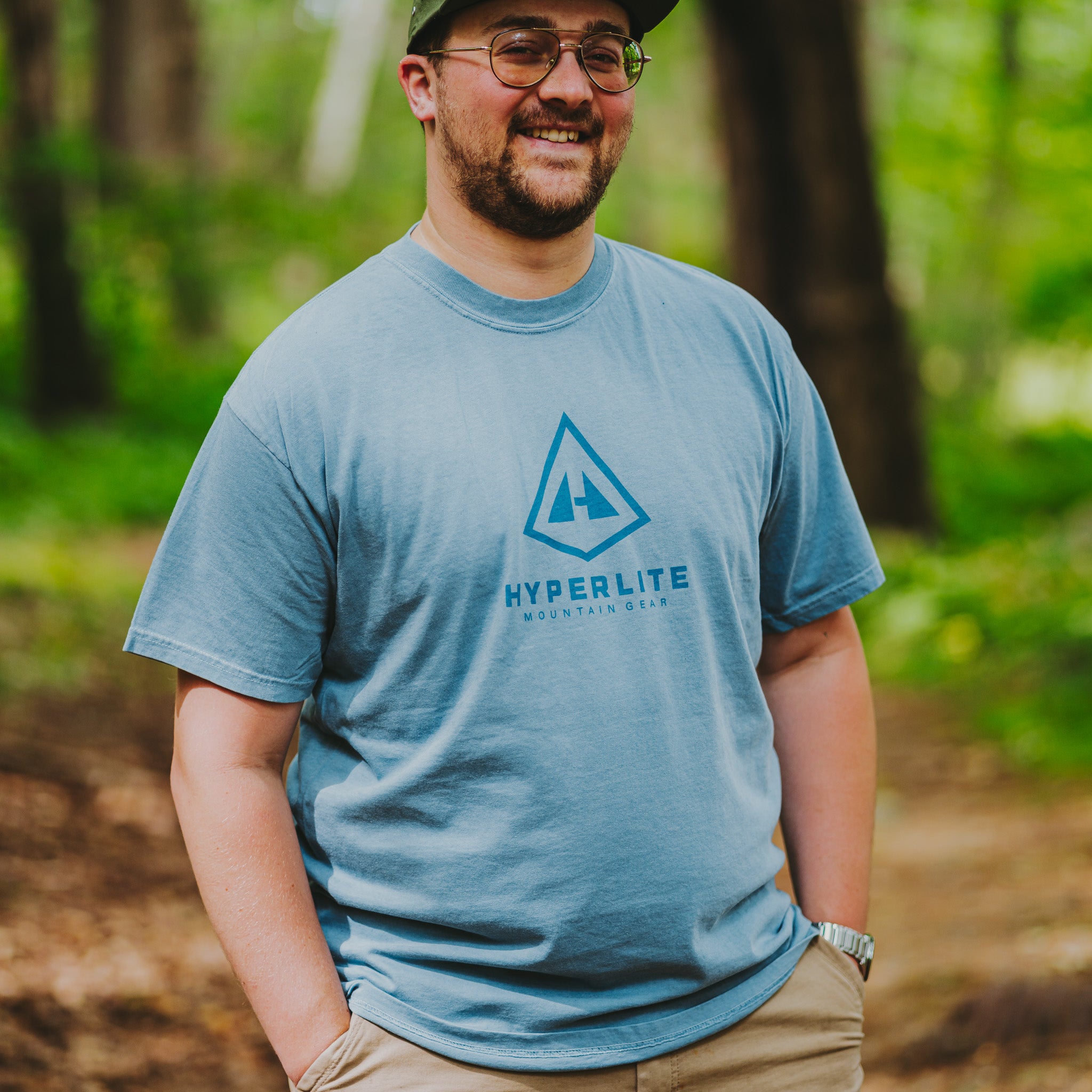 Man wearing a Hyperlite Mountain Gear t-shirt in a forest setting