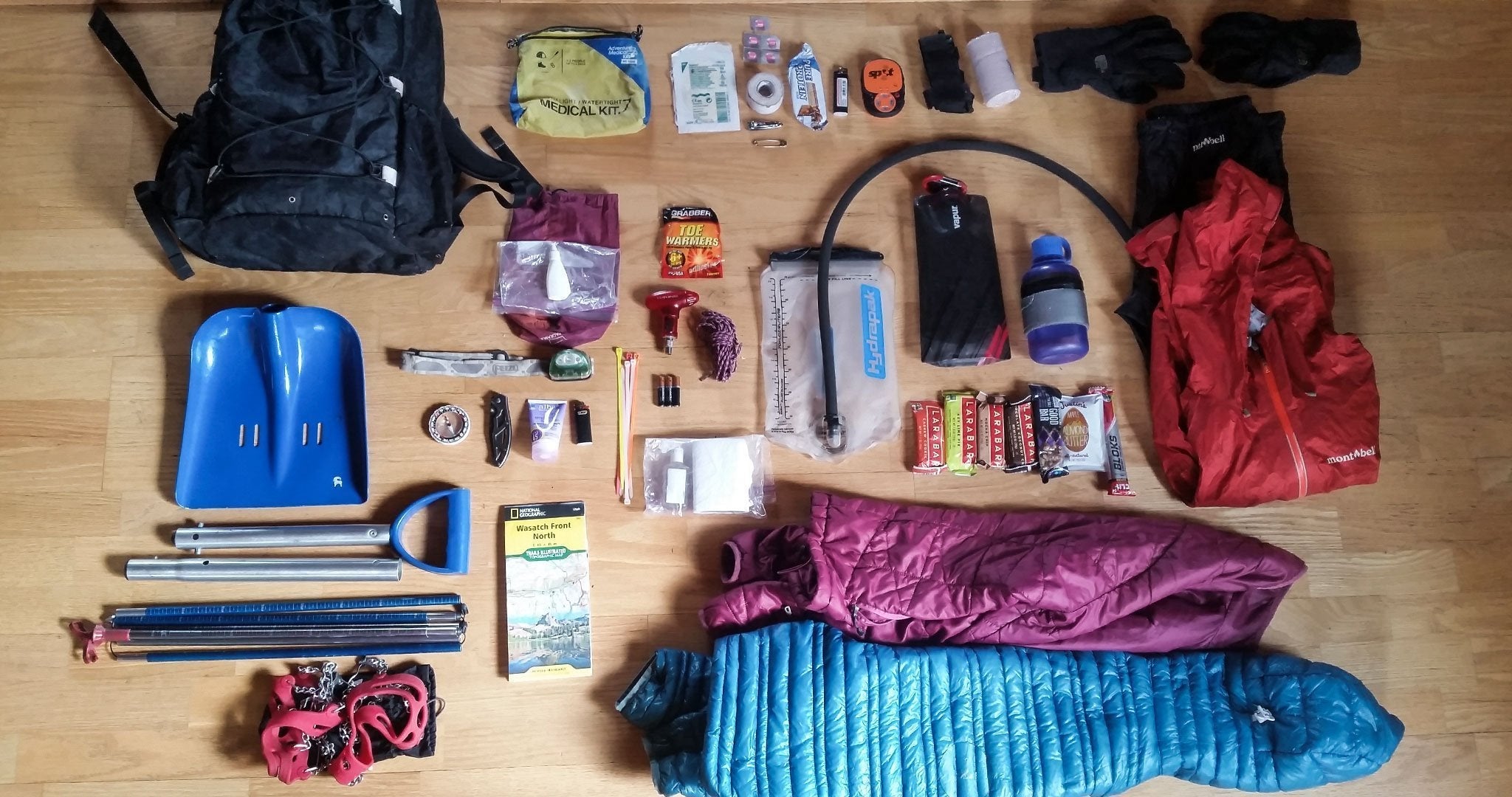 The contents of a backpack are laid out on the floor.