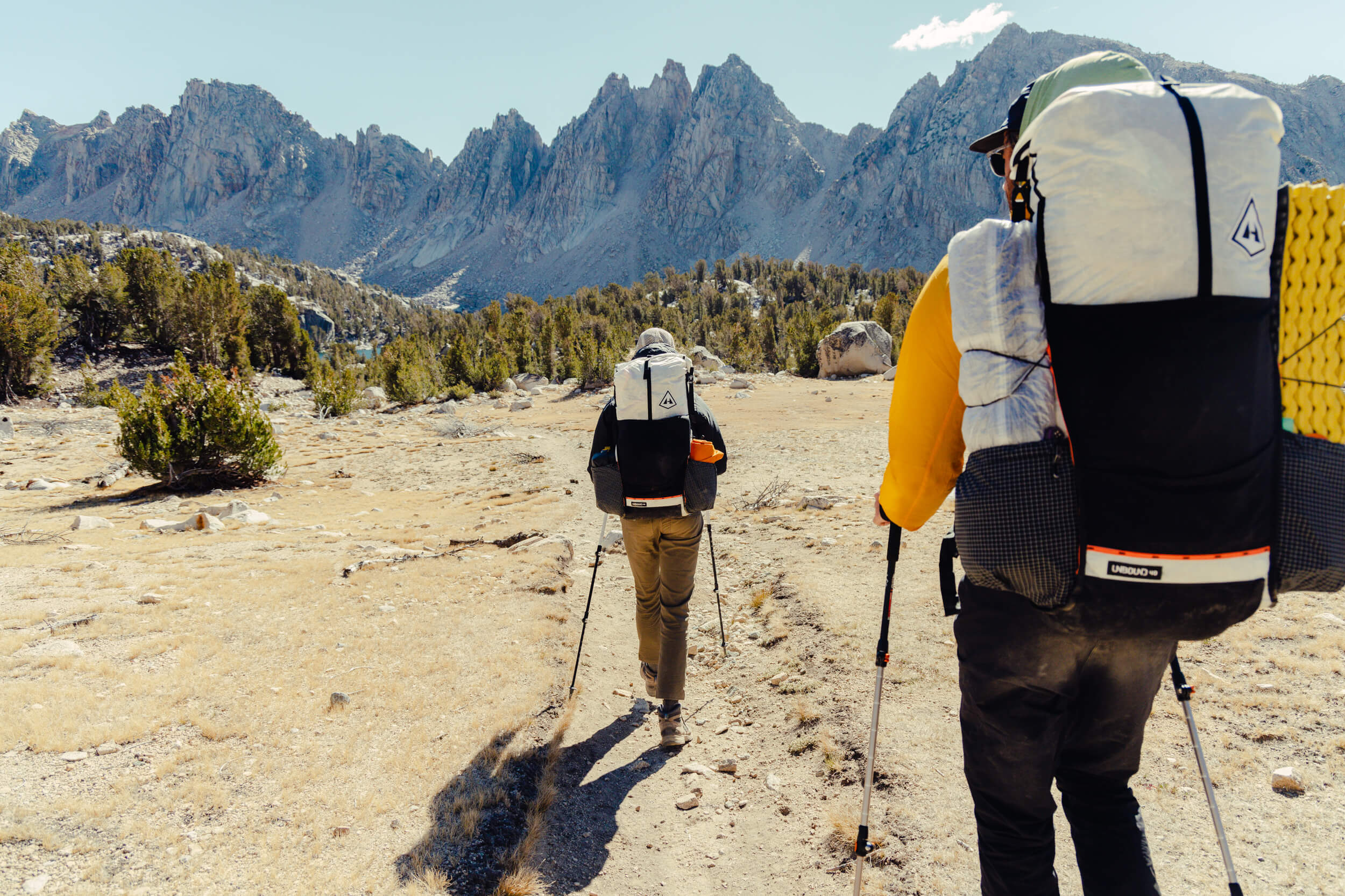 Two people walking down a trail.