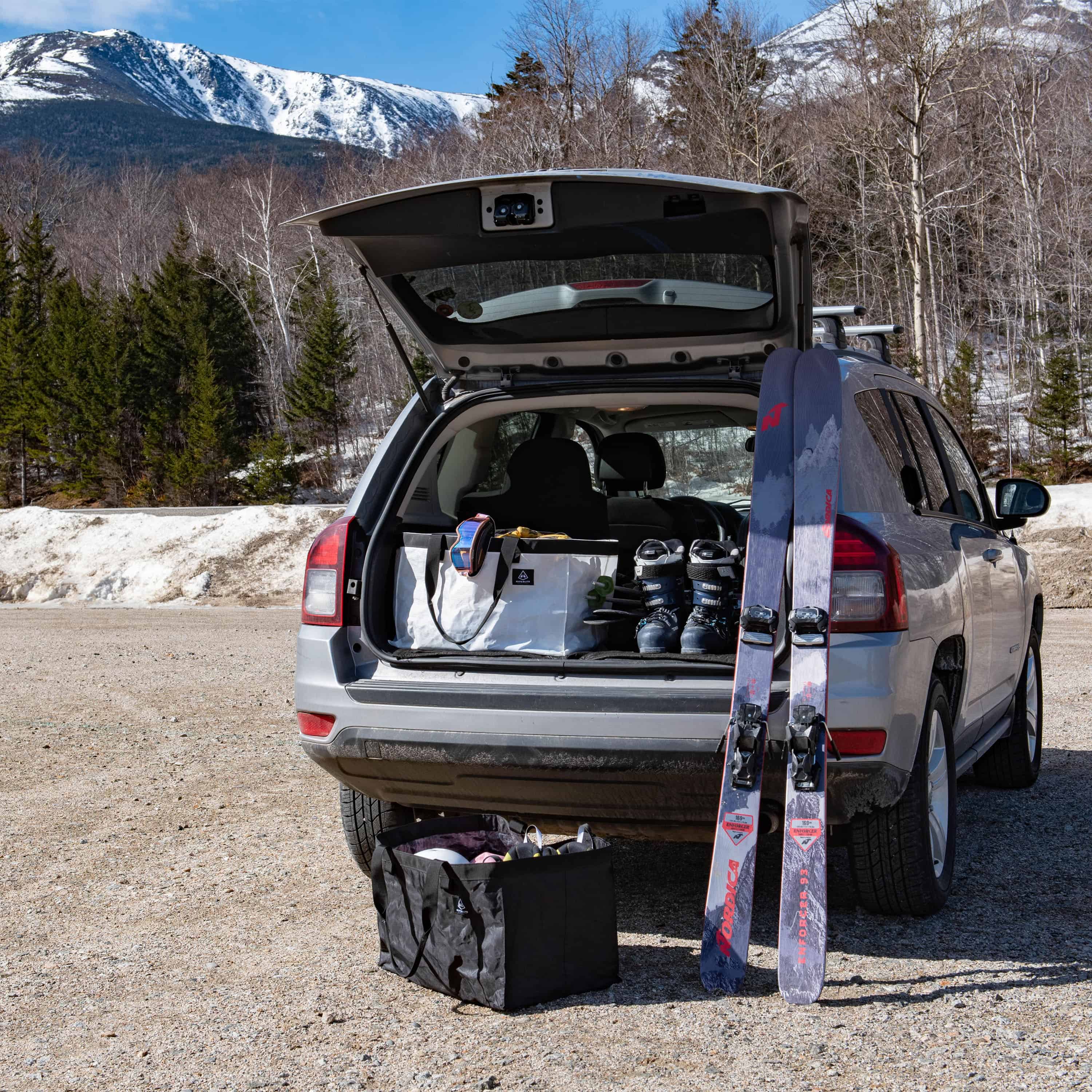 Two Hyperlite Mountain Gear G.O.A.T. Tote's filled with skiing gear by the mountains