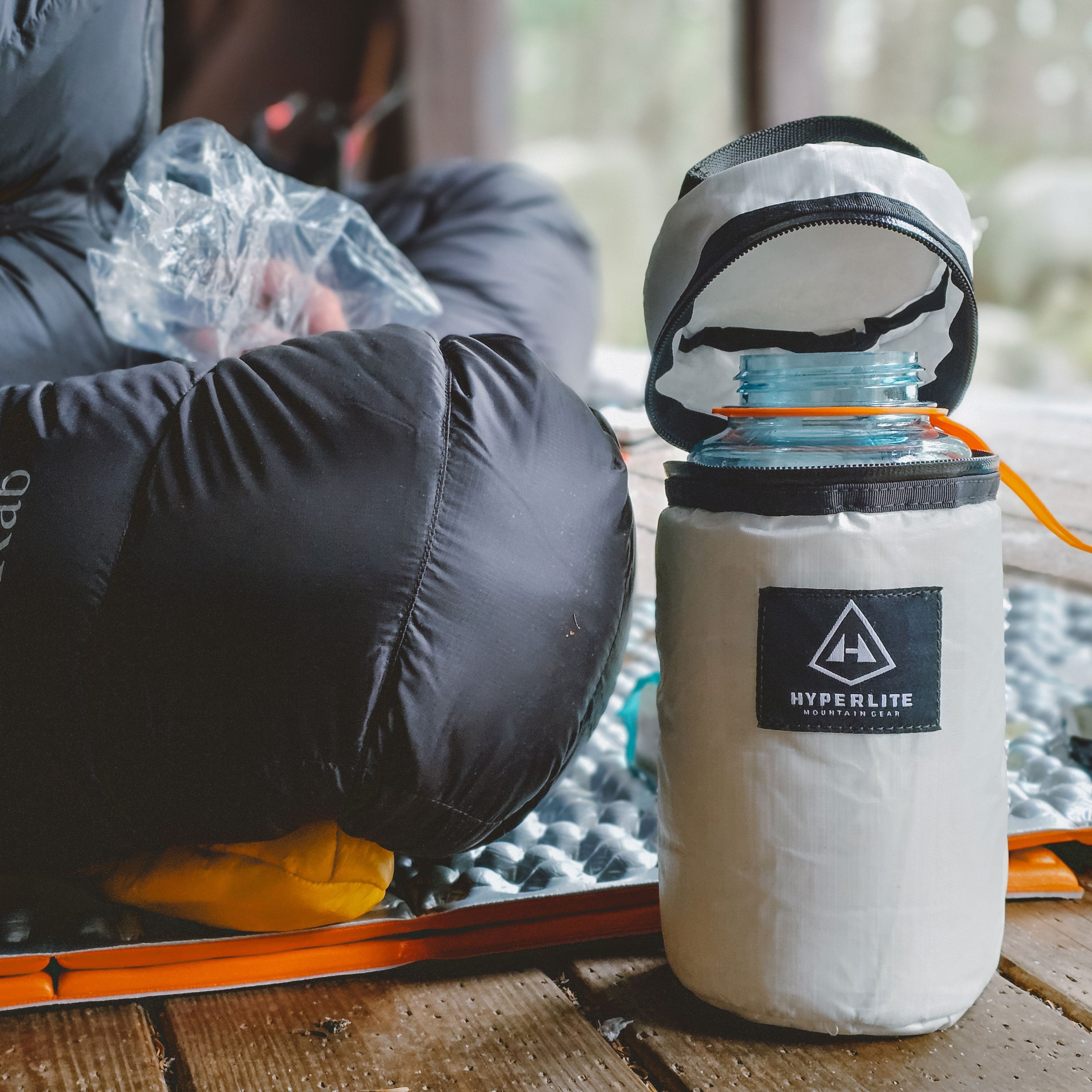 Close up of a widemouth water bottle inside of the Hyperlite Mountain Gear Insulator with the cap open