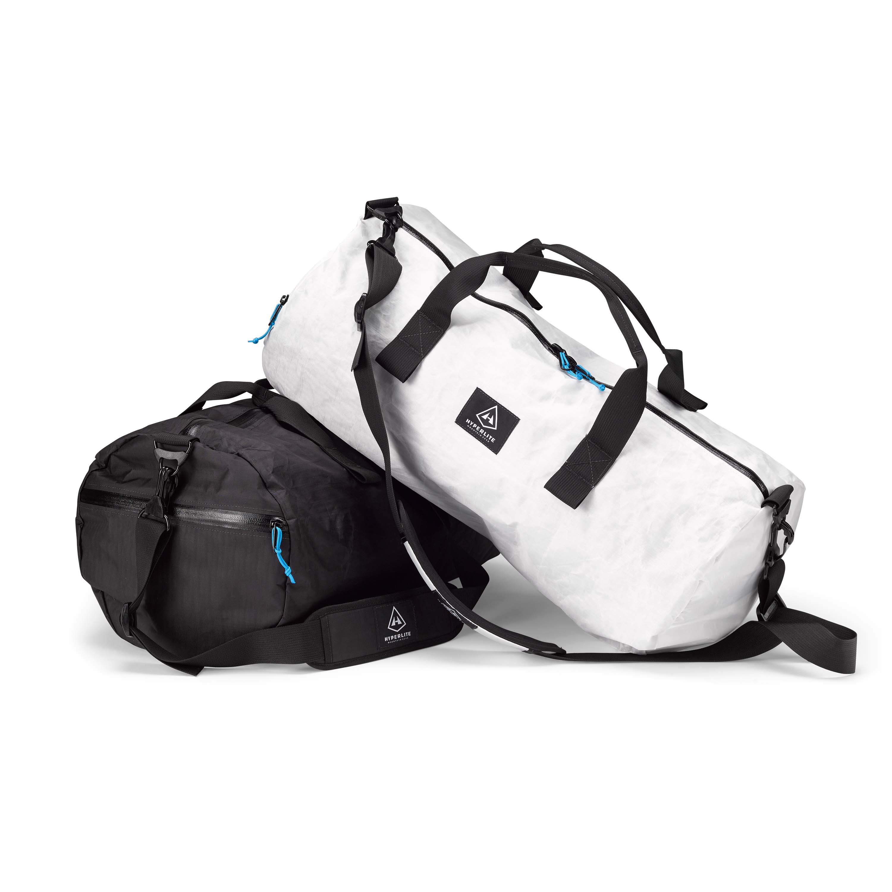 A white Hyperlite Mountain Gear 30L Approach Duffel sitting diagonally on top of a black one