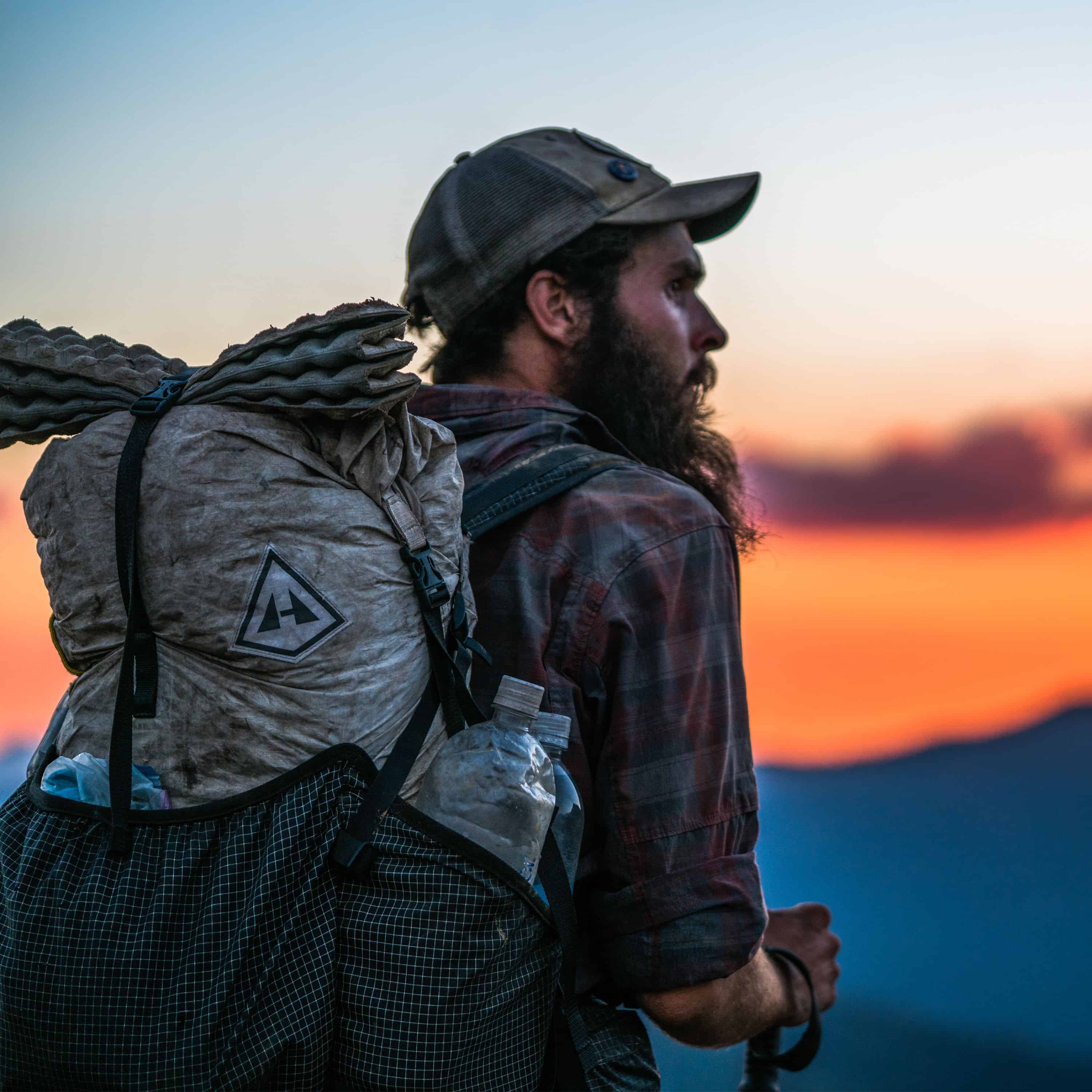 Bearded hiker reaching the summit with the Southwest 55 backpack