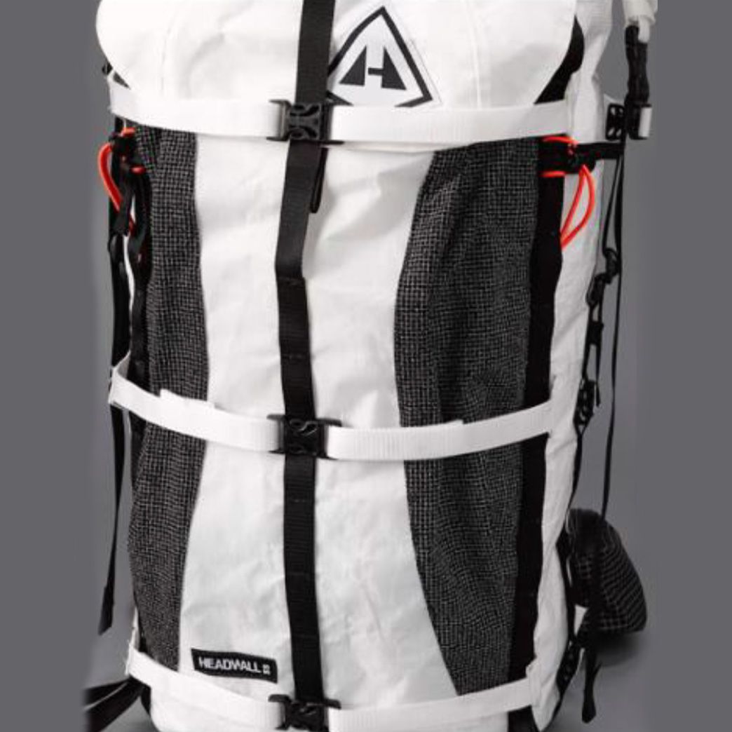 A white backpack with black straps on it.