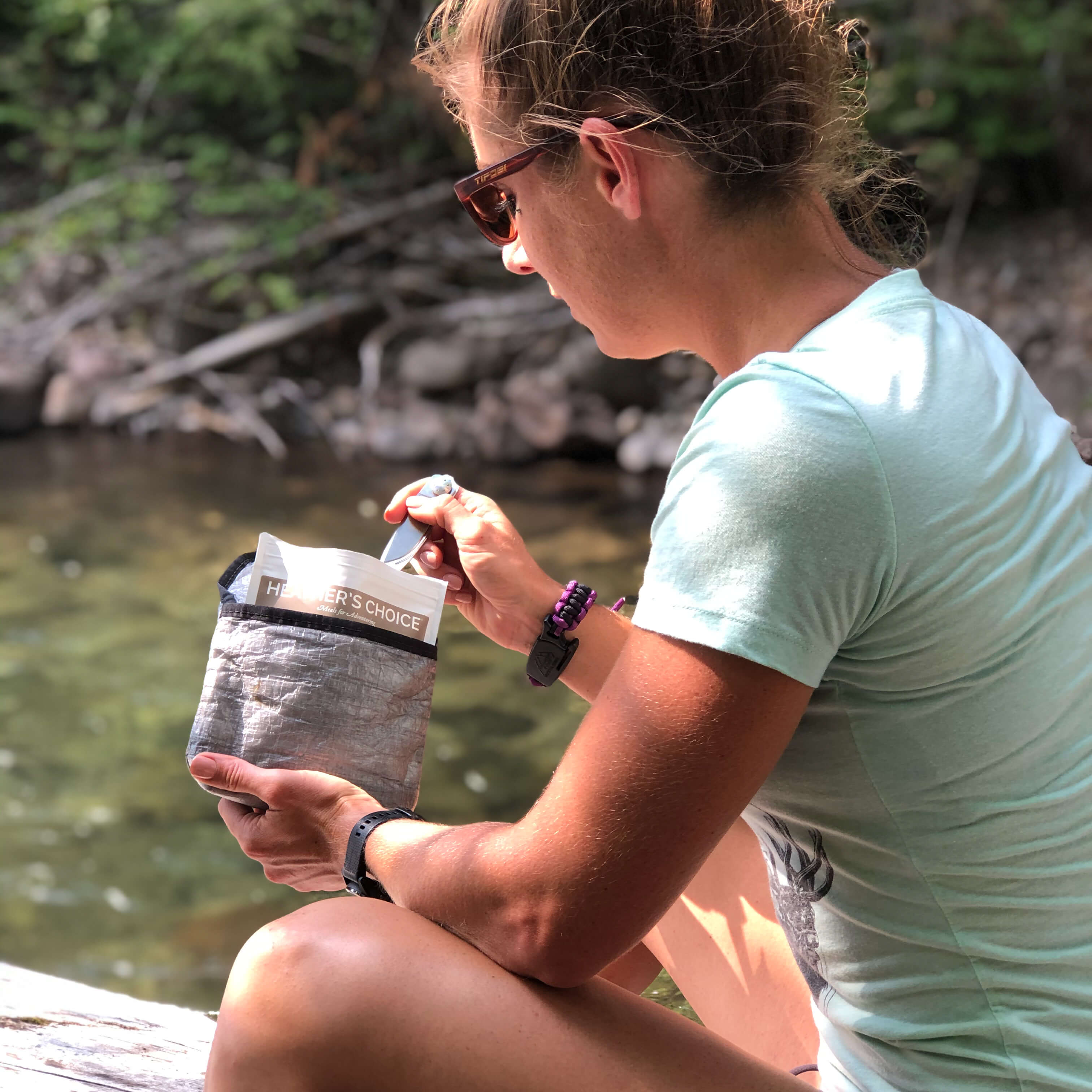 Hiker eats a camp meal kept warm by the Hyperlite Mountain Gear REpack