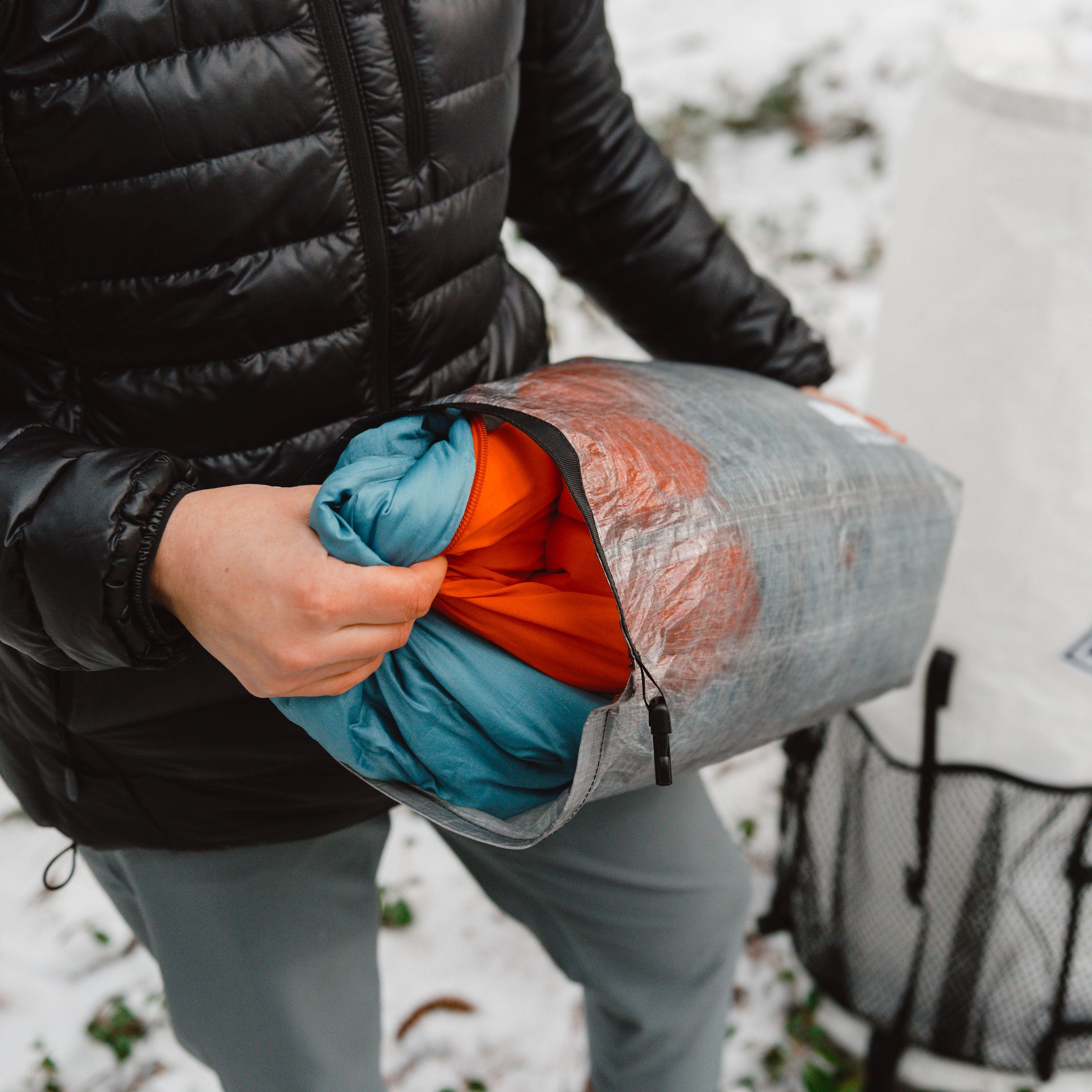 Hiker taking out clothing from Hyperlite Mountain Gear's Side Entry Pod