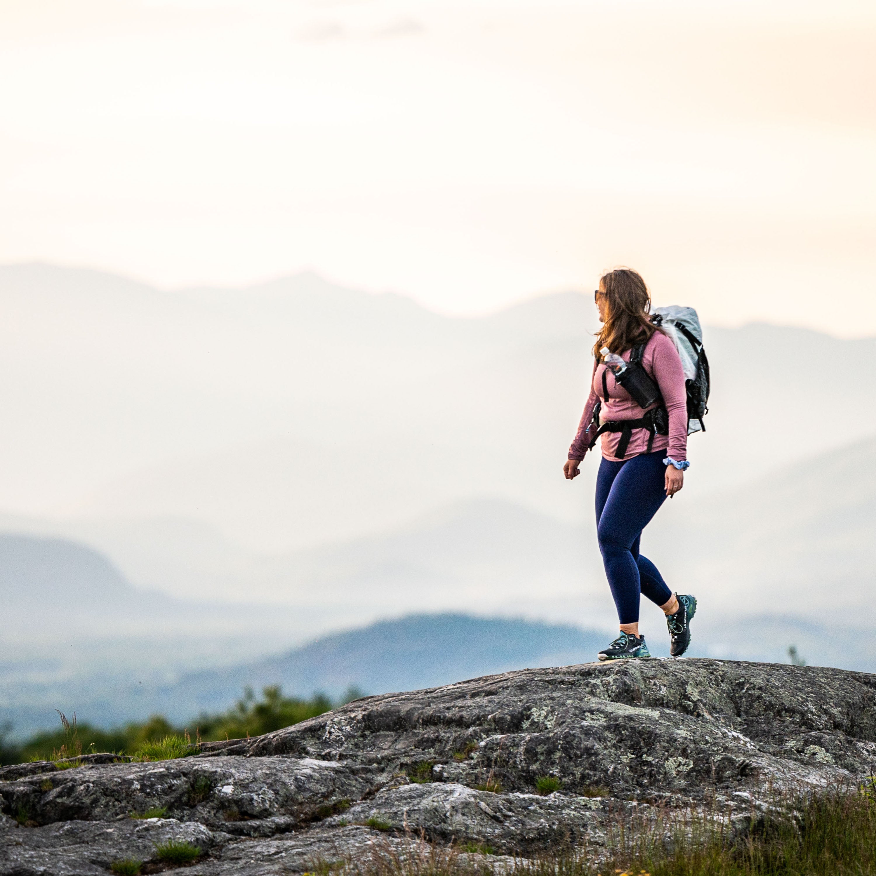 Hiker wearing Hyperlite Mountain Gear's The Bottle Pocket on backpack shoulder straps hiking on mountain