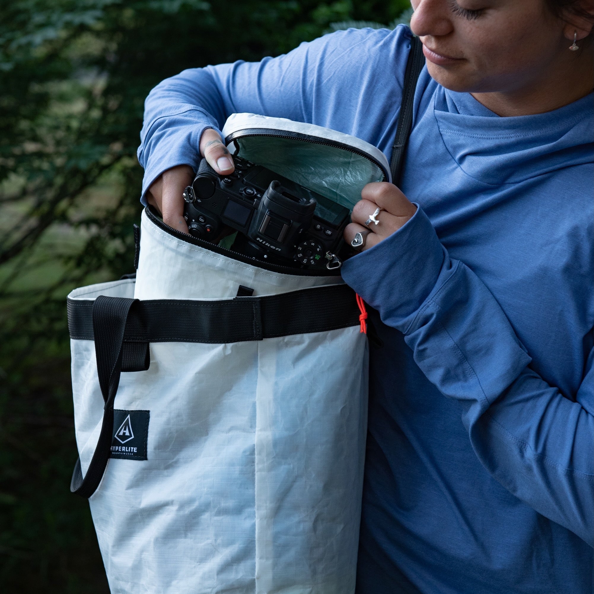 Hiker lifts the Hyperlite Mountain Gear Camera pod out of their GOAT Tote, both sold as part of the Perfect Shot Bundle