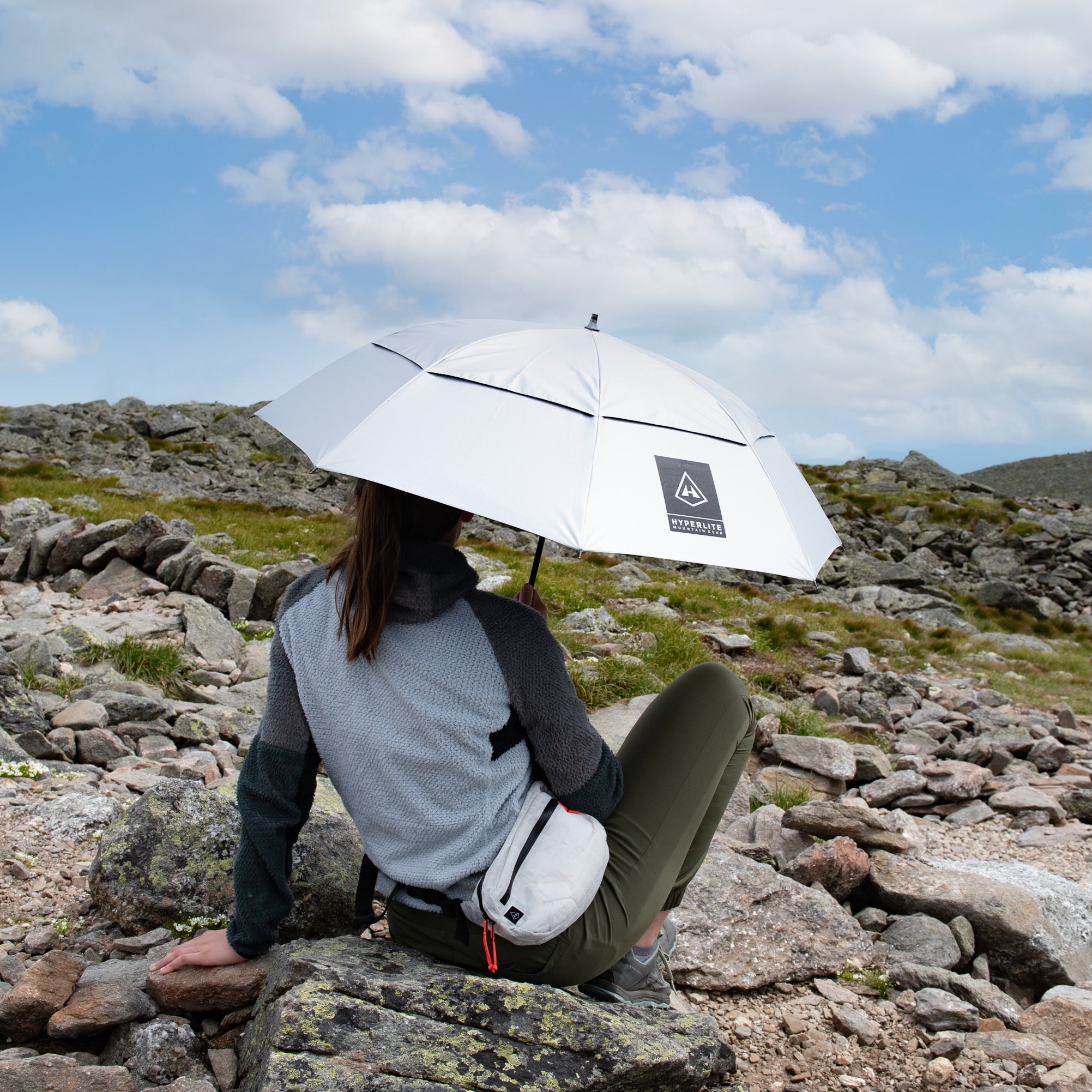 A hiker sits beside the trail wearing their Hyperlite Mountain Gear Runabout Bundle