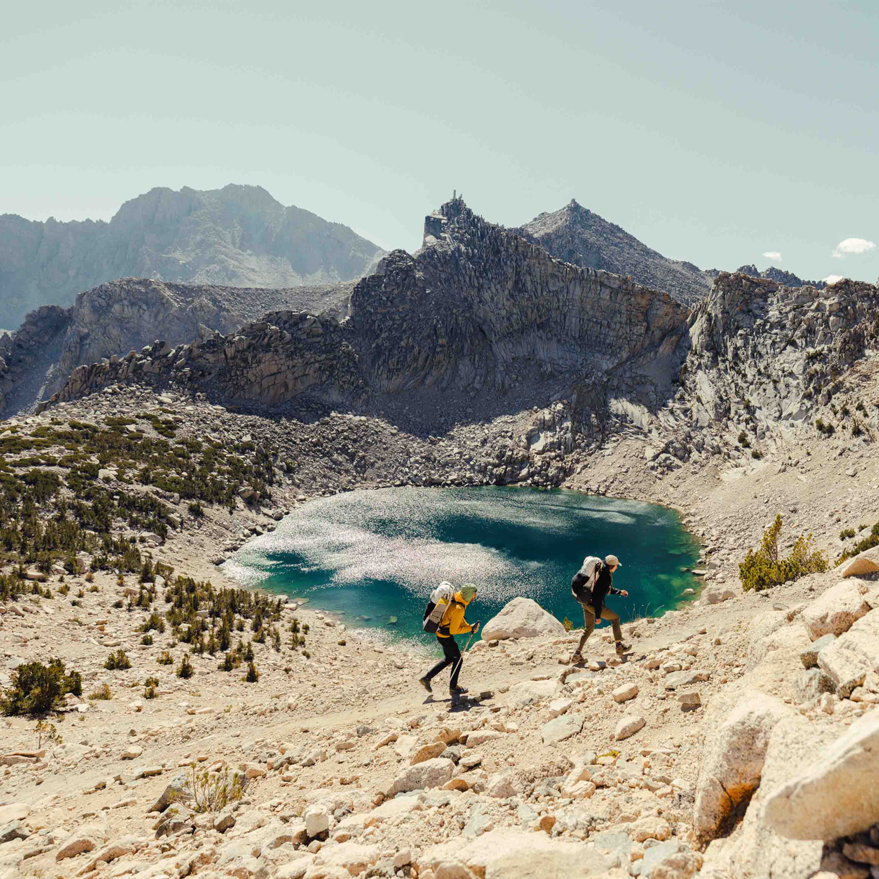 Scenic view of a lake near the summit as hikers wearing the Hyperlite Mountain Gear Unbound 40 Pack walk by